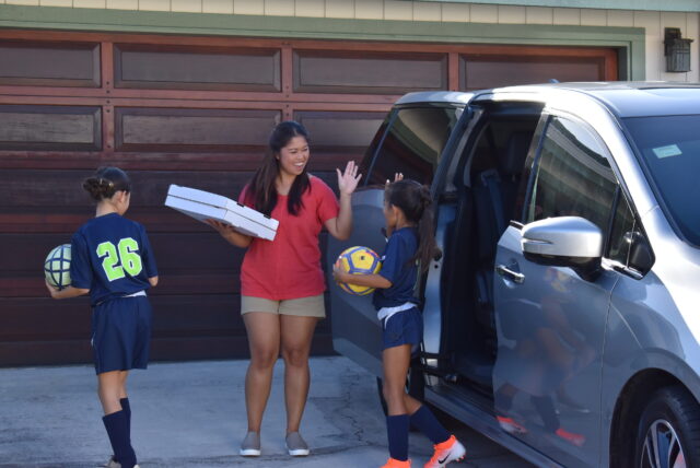 Scene from Island Insurance commercial, soccer mom high fiving little girls in uniform