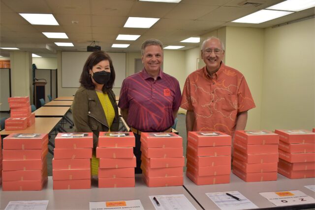 Island executives smiling at Thanksgiving pie distribution to employees